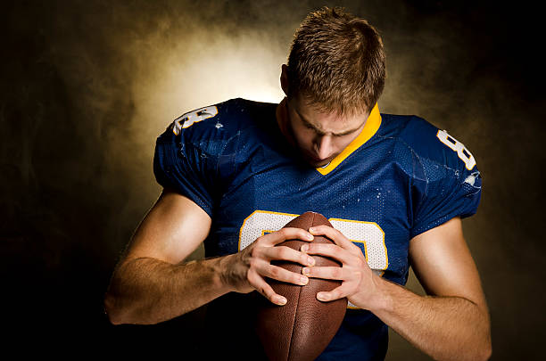 American Football Player contemplates stock photo