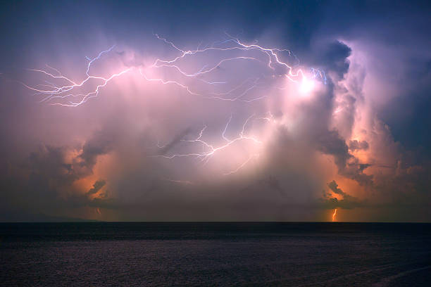 Tropical Thunderstorm A massive tropical thunderstorm passing over the ocean at midnight. Stunning colors with the rain heavily poring down. You can even see lightning moving upwards. Nikon D3X. Converted from RAW. Bulb Longterm Exposure. lightning rain thunderstorm storm stock pictures, royalty-free photos & images