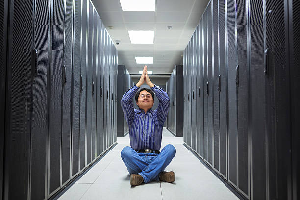 istock business man practice yoga at network server room 174842280