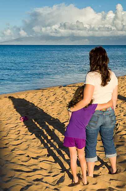 Mother Daughter Hugging at Beach stock photo