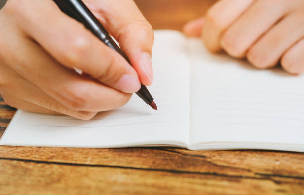 istock Woman hand writing on paper in office. 1748428572