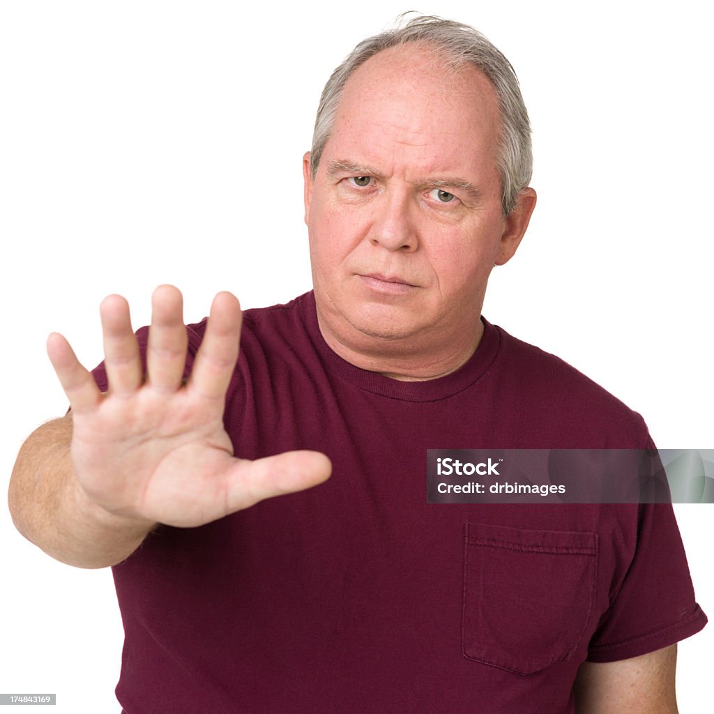 Upset Man Holds Out Hand In Stop Gesture Portrait of a mature adult man on a white background. Stop - Single Word Stock Photo