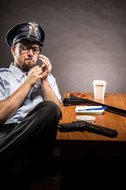 polizist auf pause beleuchtung eine zigarette - humor badge blue crime stock-fotos und bilder