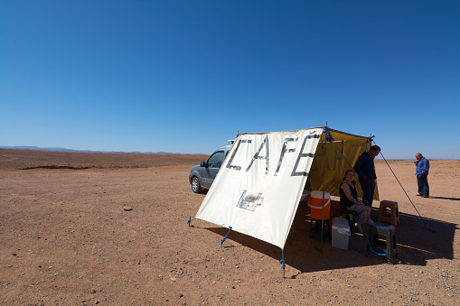 Ouarzazate, Morocco - 09 October 2023: Makeshift coffee shop in the desert with car and people