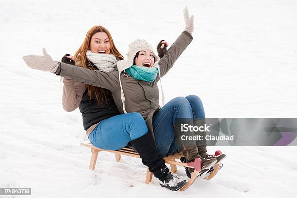 Dos Amigos En Diapositiva Foto de stock y más banco de imágenes de 25-29 años - 25-29 años, Abrigo, Abrigo de invierno