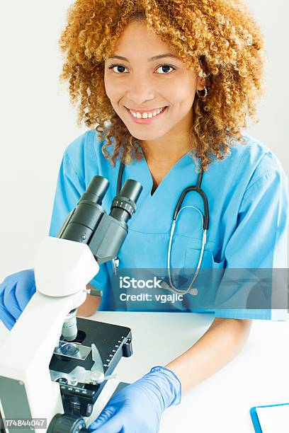 Dottore Sorridente E Lavorando Per Microscopio - Fotografie stock e altre immagini di Adulto - Adulto, Adulto di mezza età, Allegro