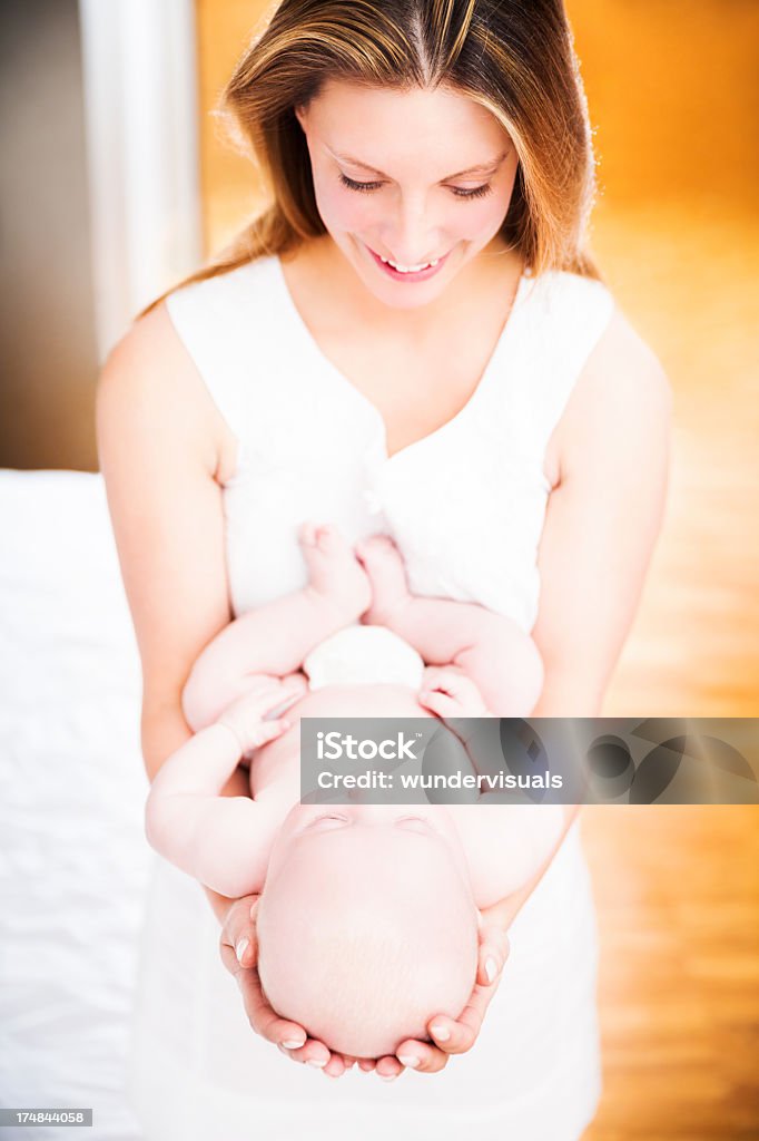 Мать держит ребе�нка в спальне - Стоковые фото 0-11 месяцев роялти-фри