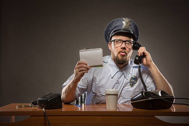 frustrado cop por teléfono - desk police police station humor fotografías e imágenes de stock