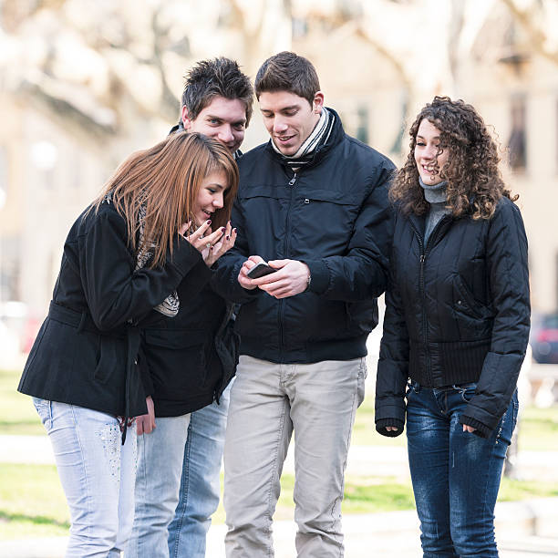 istock friends using a smarthpone outdoors 174844739