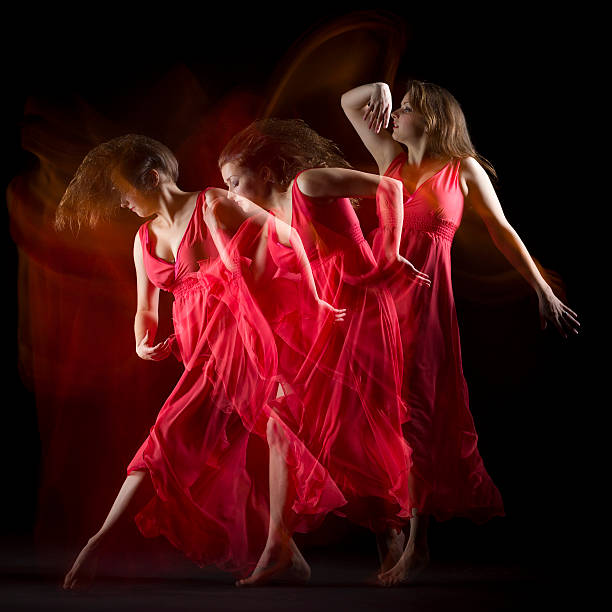 istock Female Dancer in red dress build patterns on black 174845383