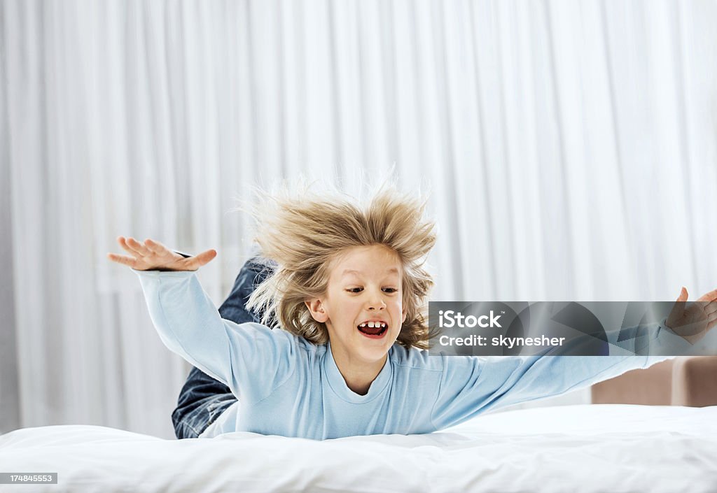 Mignon petit garçon sauter sur le lit. - Photo de Enfant libre de droits