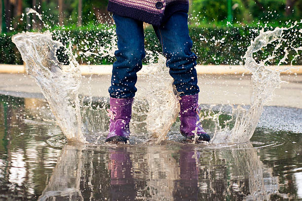 水たまりでジャンプ - rain drenched one person standing ストックフォトと画像