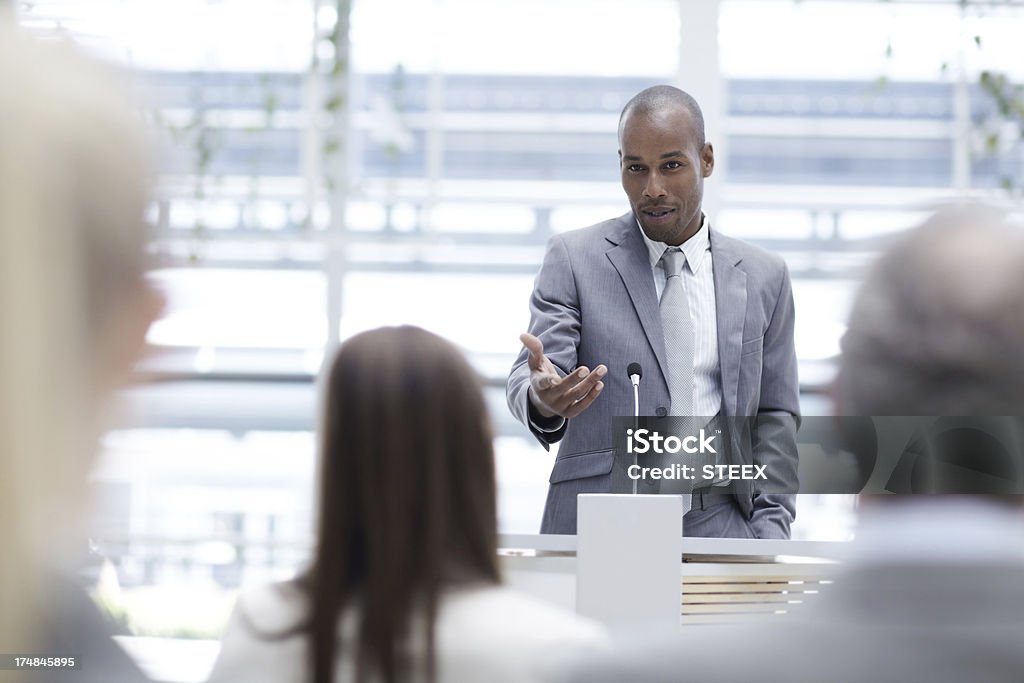 Appreciating a colleague's input A handsome young executive seeking his colleagues' input while delivering a speech at a seminar Group Of People Stock Photo