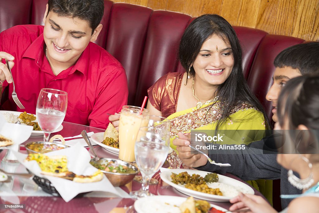 Madre godendo la cena con i bambini al ristorante indiano - Foto stock royalty-free di Cultura indiana
