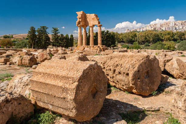 due grandi colonne nella valle dei templi di agrigento; il tempio dei dioscuri sullo sfondo - valle dei templi foto e immagini stock