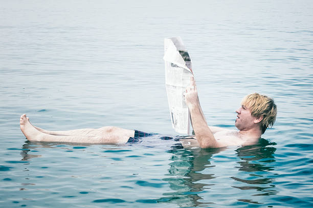 istock Reading newspaper in the Dead Sea 174846955
