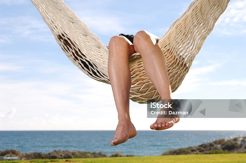 Persona descansando en una balanceo de una hamaca en la playa. - Foto de stock de Hamaca libre de derechos