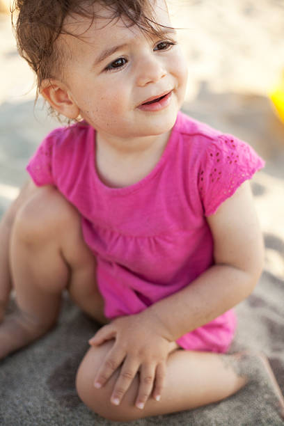 istock cute baby girl at beach 174847380