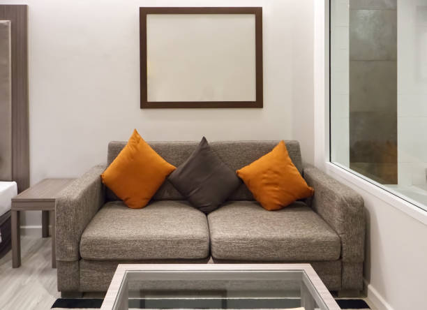istock Beautiful three pillows on sofa with empty frame picture interior decoration in living room, home related background 1748478293