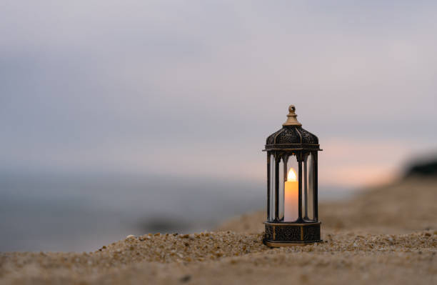 istock Islamic Lantern on rock with blurry sea beach background.Eid decorative traditional lamps illuminated ready for the Holy season of Ramadan Kareem,Eid Al fitr,Eid al Adha,Eid Mubarak,Muharram 1748478613