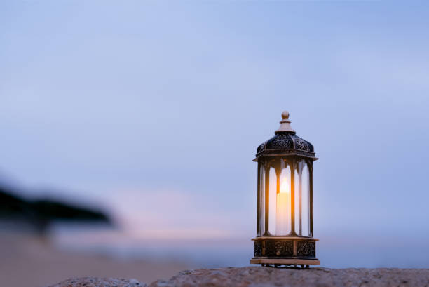 istock Arabic Lantern on rock with blurry sea beach background.Eid decorative traditional lamps illuminated ready for the Holy season of Ramadan Kareem.,Eid Al fitr,Eid al Adha,Eid Mubarak 1748478653