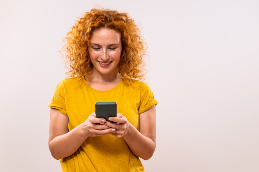 Image of happy ginger woman using phone.