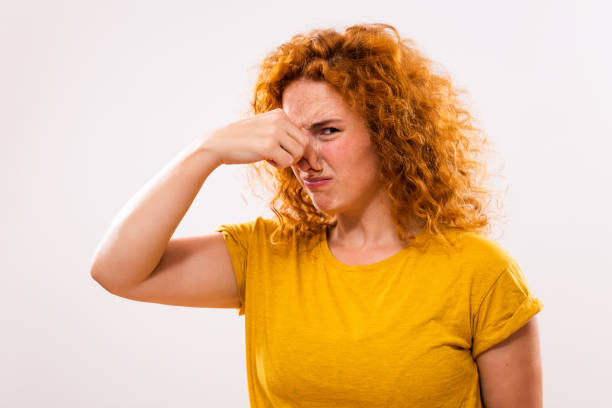 Unpleasant smell Shocked ginger woman doesn't like how something smells. holding nose stock pictures, royalty-free photos & images