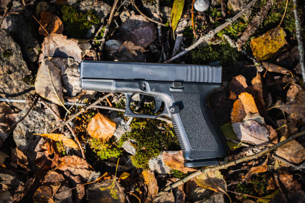 istock Firearm, pistol with a plastic frame on an autumn background of leaves. 1748486261