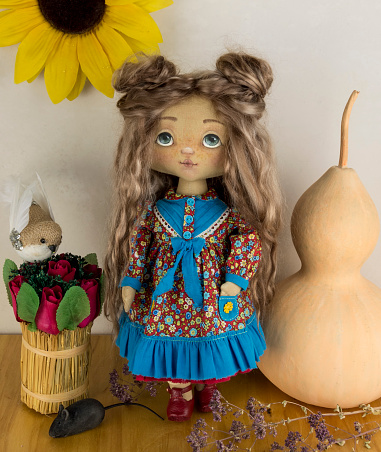 Handmade textile doll with pumpkin and flowers.
