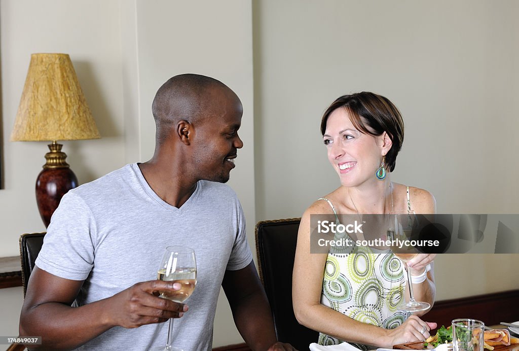 Young Caucasian Woman and Colored Man in Restaurant A young caucasian woman and a colored man having a good time in a restaurant 30-39 Years Stock Photo