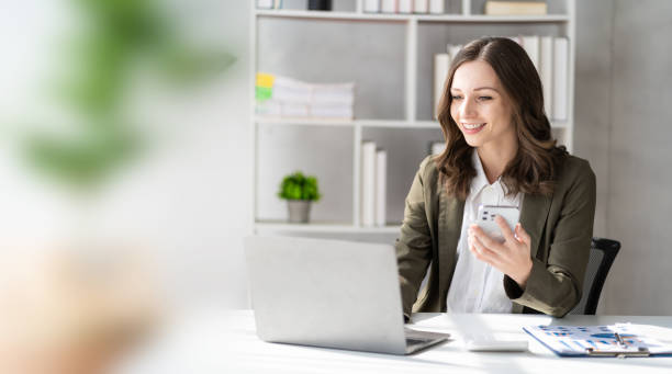 istock Happy young woman calling her friend talking and asking about something using laptop, middle aged business woman, female professional manager talking on the phone doing business on mobile phone 1748490371