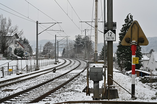 Railway tracks with level crossing in winter. On the foreground there is technology for level crossing with ramp.