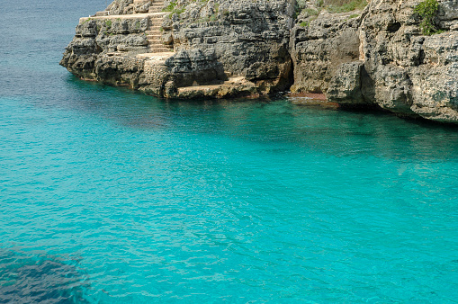 Seascape with emerald water between rocky coast in solitude