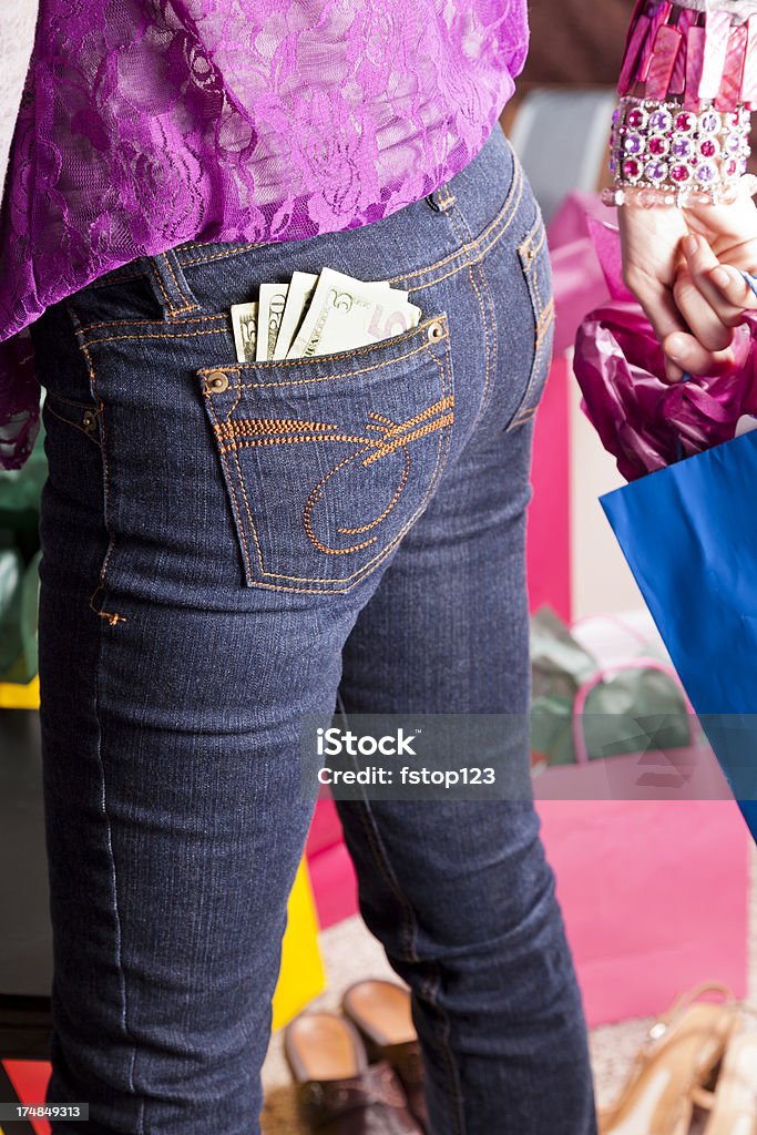 Consumismo. Mujer con dinero en el bolsillo y balanceo bolsa de la compra - Foto de stock de 30-39 años libre de derechos