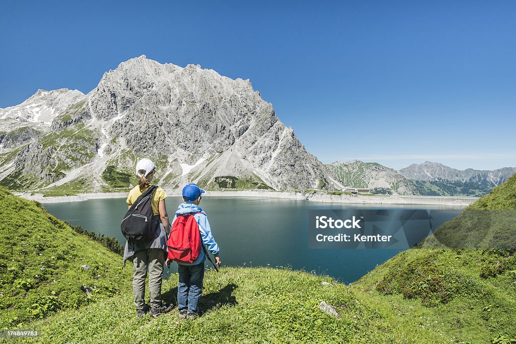 kids hiking in the mountains two children looking at a lake in the austrian mountains Hiking Stock Photo