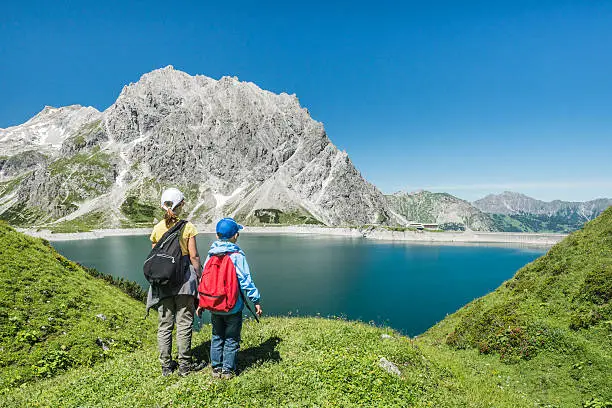 two children looking at a lake in the austrian mountains