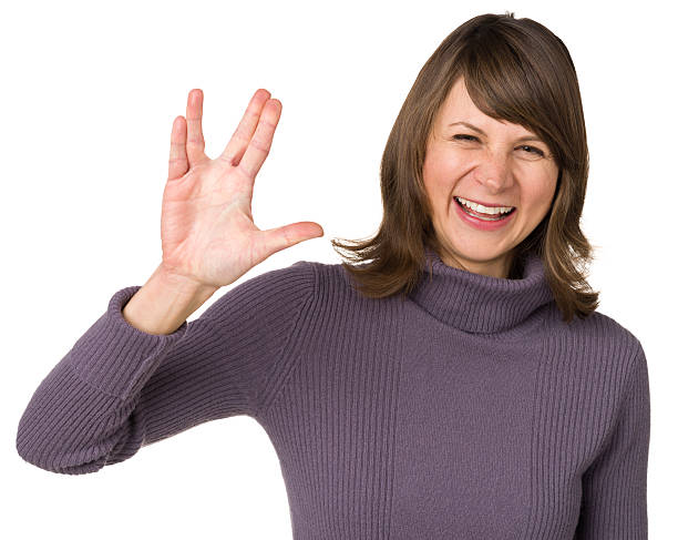 Woman Gestures Vulcan Salute Hand Sign Portrait of a woman on a white background. vulcan salute stock pictures, royalty-free photos & images