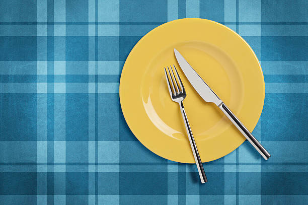 Yellow plate on Plaid tablecloth stock photo