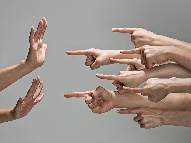 Group of hands with pointing finger Multiple white hands are pointing index fingers from the right to the left at one set of hands.  The pair of hands that are being pointed at are up in a defensive pose, with fingers to the sky and palms towards the pointing fingers. guilty stock pictures, royalty-free photos & images