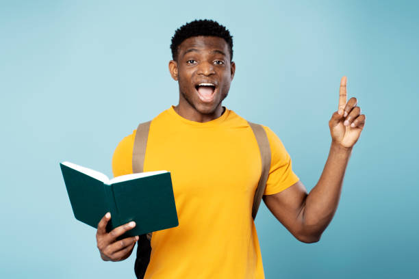 istock Smart African American student with backpack holding book having idea isolated on blue background 1748506859