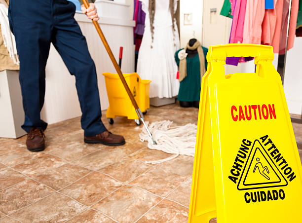istock Services:  Caution sign and custodian mopping retail store floor 174850750