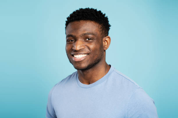 istock Smiling nigerian man standing isolated on blue background in blue tshirt looking at camera 1748512372