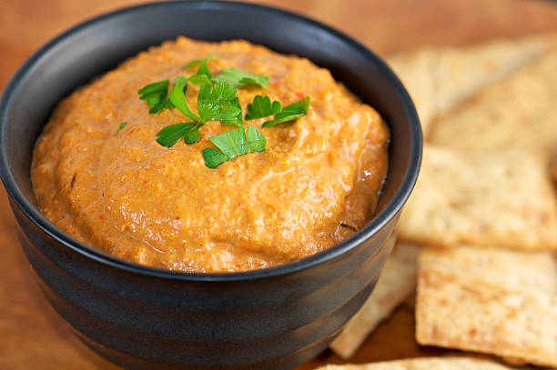 istock Red Pepper Dip in Black Bowl with Pita chips 174851779