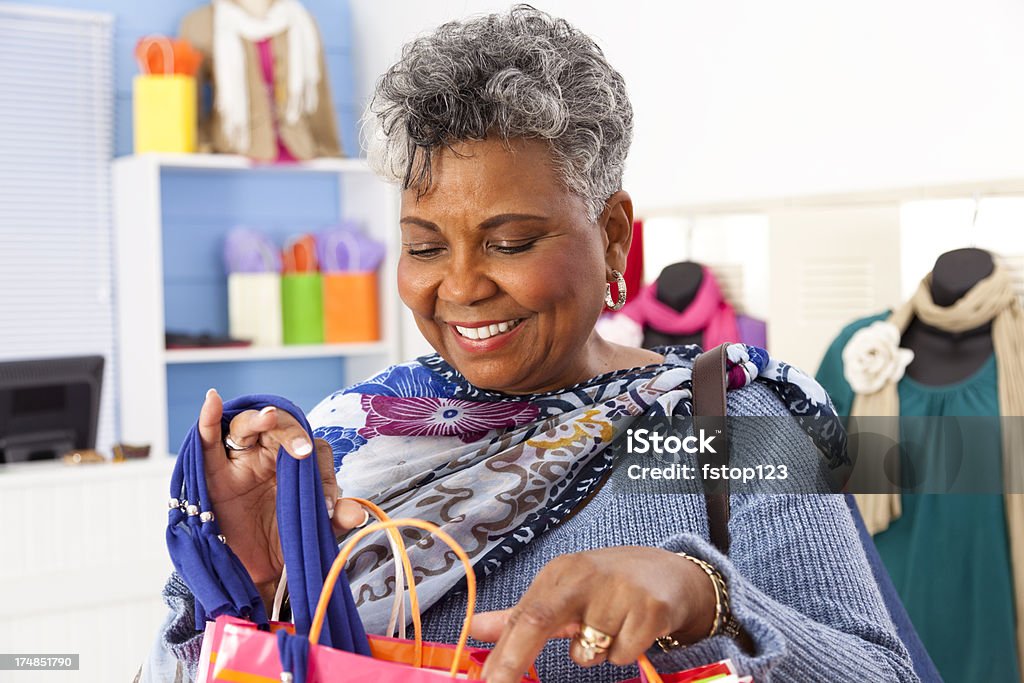 Konsumpcjonizm: Starszy Afrykańskiego Schodzenia kobieta zadowolony z zakupu w sklepie boutique - Zbiór zdjęć royalty-free (Afrykanin)