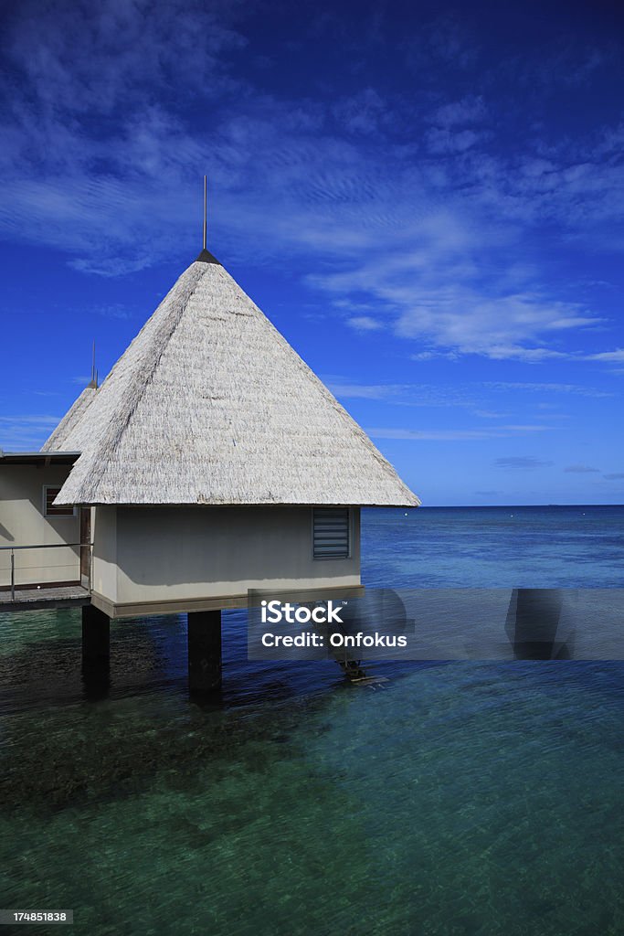 Tropical Paradise Luxury Over Water Bungalow Resort DSLR picture of a Luxury over water bungalow inside a lagoon.  The water is crystal clear and calm. The sky is clear blue with few clouds. Bungalow Stock Photo