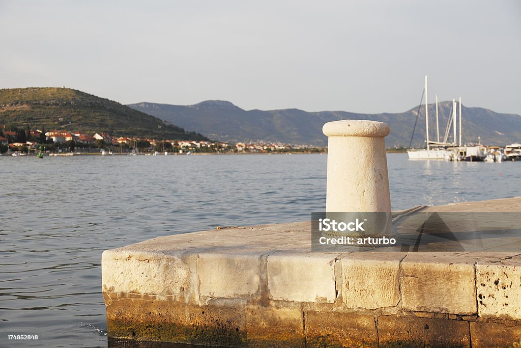 bollards y al mar Mediterráneo con barco de vela al puerto en Croacia - Foto de stock de Agua libre de derechos