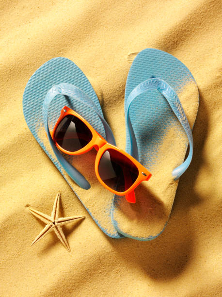istock Blue Flip Flops with Orange Sunglasses on the Beach 174852952