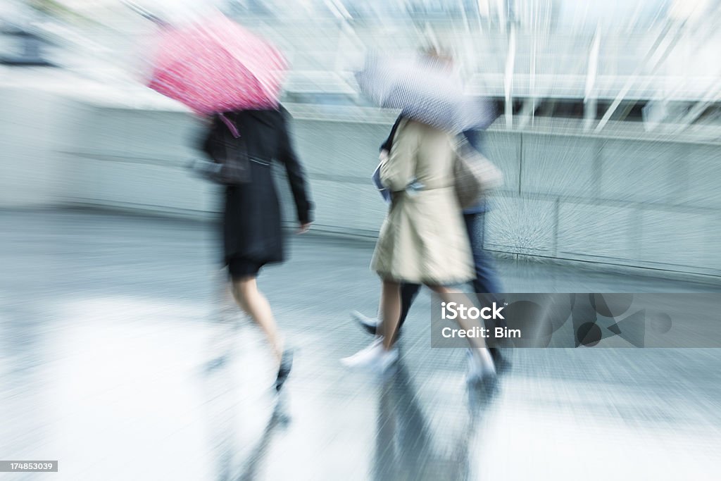 Затуманенное люди с зонтиками ходить на прогулку в дождливый день - Стоковые фото Буря роялти-фри