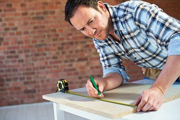 istock Construction Worker Measuring Plank Of Wood 174853089