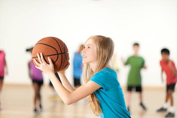 Young girl playing basketball taking free throw.
